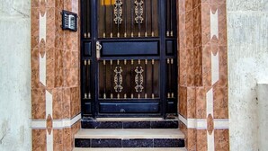 A black gate with ornate metalwork, a tiled entrance with steps, and signs indicating "IM 291" and "GH 21". - Wohnung "Loft in Tanger" by Interhome (Tanger)