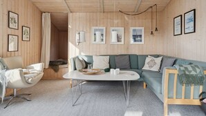 A cozy living room with a wooden interior, a white sofa, a green sofa, a white coffee table, and a white armchair. - "Yma" - 250m from the sea by Interhome (Juelsminde)