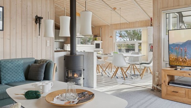 A modern living room with a fireplace, a dining area, and a kitchen. - "Yma" - 250m from the sea by Interhome (Juelsminde)