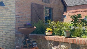 A brick building with a stone wall and a wooden wheelbarrow. - Alte Schmiede by Interhome (Boitzenburger Land)