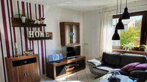 A modern living room with a sofa, a glass coffee table, a TV, and a cabinet. - Casa Maria in Ehrenberg an der Rhön by Interhome (Ehrenberg)
