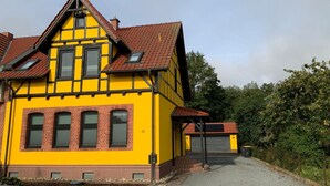 A yellow building with a red roof, a garage, and a driveway. - Machold by Interhome (Nordhausen)