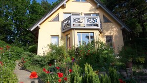 A two-story house with a balcony, surrounded by a garden with red flowers. - mit Garten in ruhiger Lage by Interhome (Bansin)