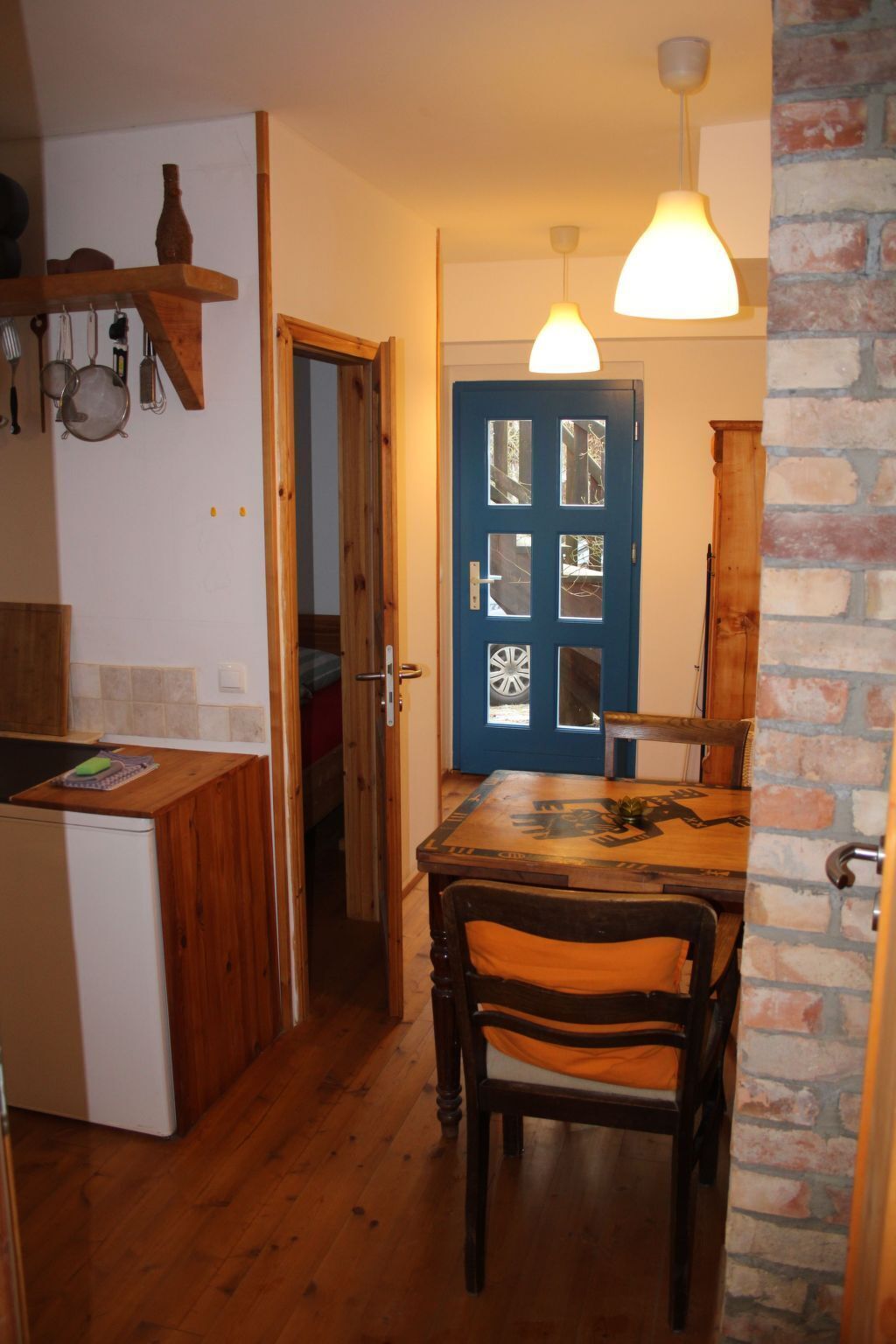 Eine Küche mit Holzausstattung, einem Spülbecken und einem Essbereich mit Tisch und Stühlen.