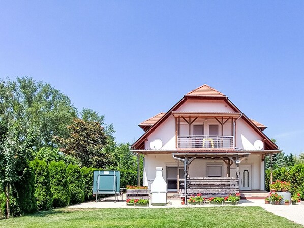 A two-story house with a balcony, a small porch, and a garden. - Apartment am See by Interhome (Balatonmariafurdo)