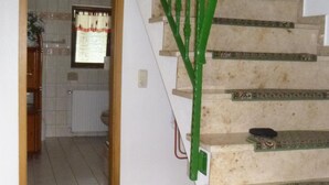 Una escalera con barandilla verde que da a un rellano.
