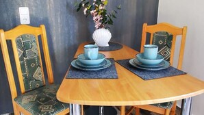A dining area with a wooden table, two chairs, and a vase with flowers. - Appartement in Lütow mit Grill by Interhome (Krummin)