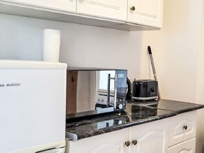 A kitchen with a microwave, toaster, and a white refrigerator. - Vacation home am See by Interhome (Balatonmariafurdo)