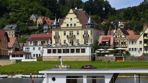 A boat with "Nationalpark Lime" written on its side, docked near a building with balconies and a sign that reads "Strandhotel." - Haus am Stein Haus 2 by Interhome (Königstein)