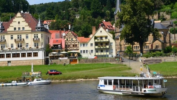 A riverside town with historic buildings, a boat, and a grassy area. - Haus am Stein Haus 2 by Interhome (Königstein)