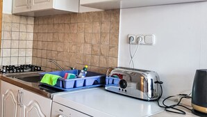 Eine Küche mit weißen Schränken, einem Bosch-Toaster und einem blauen Geschirrgestell.