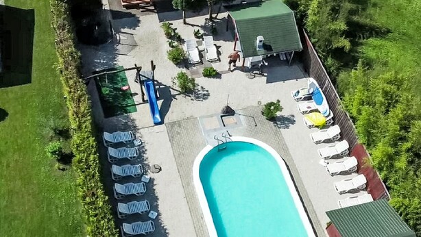 An aerial view of a swimming pool area with lounge chairs, a pool, and a small building. - Vacation home am See by Interhome (Balatonmariafurdo)