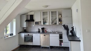 Eine moderne Küche mit weißen Schränken, einem Einbauofen, einer Mikrowelle und einem Geschirrspüler.