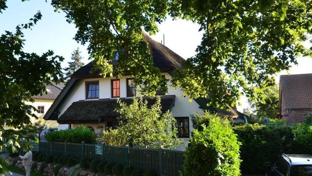 A traditional house with a stone wall, a thatched roof, and a paved driveway. - Haus Strandhafer by Interhome (Baabe)