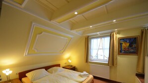 A hotel room with a double bed, bedside tables, a window with curtains, a radiator, and a painting on the wall. - Haus Strandhafer by Interhome (Baabe)
