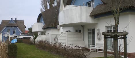 A house with a unique architectural style, featuring a curved roof and a white exterior.