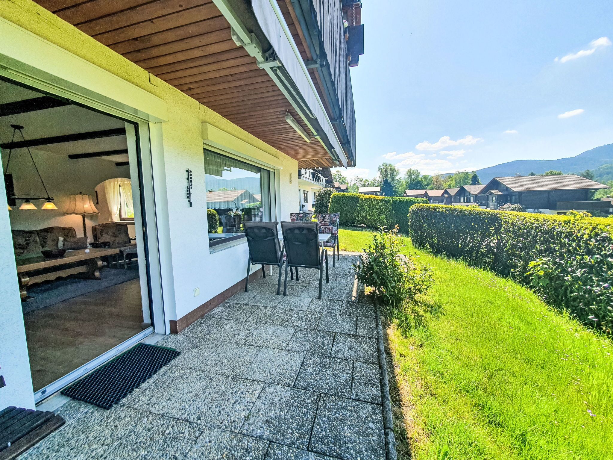 Un patio con posti a sedere all'aperto, vista di un giardino curato e scorcio del paesaggio circostante.