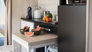 Una cocina moderna con microondas, hervidor y frutero con rebanadas de sandía.