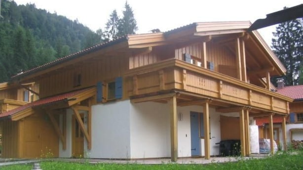 A two-story wooden chalet with a balcony, a covered porch, and a red fire hydrant in the foreground. - Chalet Sachrang by Interhome (Aschau im Chiemgau)