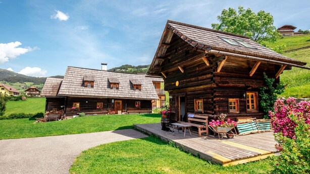 Eine Holzhütte mit Veranda und kleinem Garten.