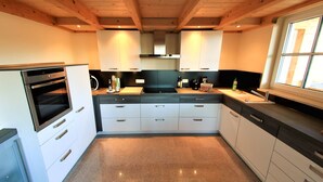 Een moderne keuken met een ingebouwde oven, witte kastjes en een granieten werkblad.
