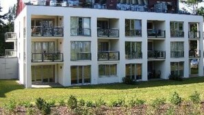 A multi-story building with balconies, large windows, and a flat roof. - Traumappartement am Strand by Interhome (Breege)