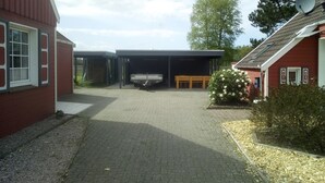A covered outdoor area with a bench, a small table, and a truck parked. - Kleine Ferienwohnung in ruhiger Lage by Interhome (Westoverledingen)