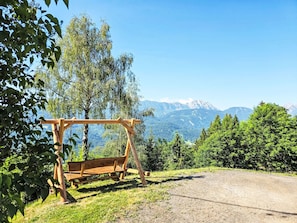 Une balançoire en bois installée dans un cadre naturel, offrant une vue dégagée sur les montagnes lointaines.