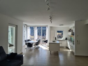 A modern kitchen with a dining area, large windows, and a view of the outdoors. - Haus Kreischberg by Interhome (Sankt Georgen am Kreischberg)