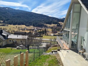 A modern building with large windows overlooking a valley with houses and mountains. - Haus Kreischberg by Interhome (Sankt Georgen am Kreischberg)