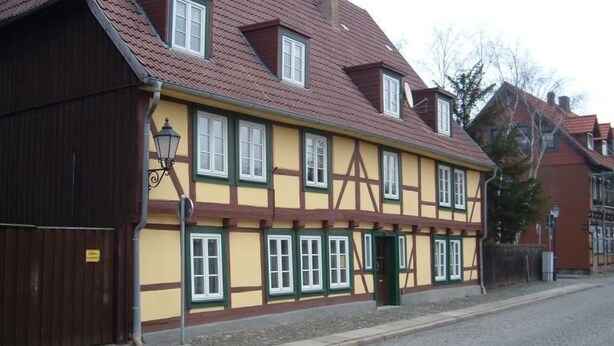Un b âtiment traditionnel à colombages, doté d’un toit à pignon, de nombreuses fenêtres et d’un lampadaire.