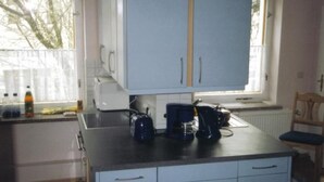 Una cocina con gabinetes azul claro, un ventanal y una cafetera en la encimera.