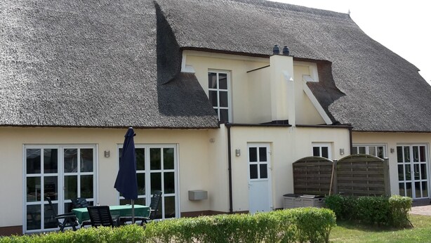 A building with a thatched roof, a small porch with chairs and a table, and a gate. - Tante Waltraut in Garz auf Usedom by Interhome (Ahlbeck)