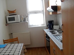 A compact kitchen with a microwave, coffee maker, and stove. - Strandnahe Ferienwohnung in Gründerzeitvilla by Interhome (Ahlbeck)