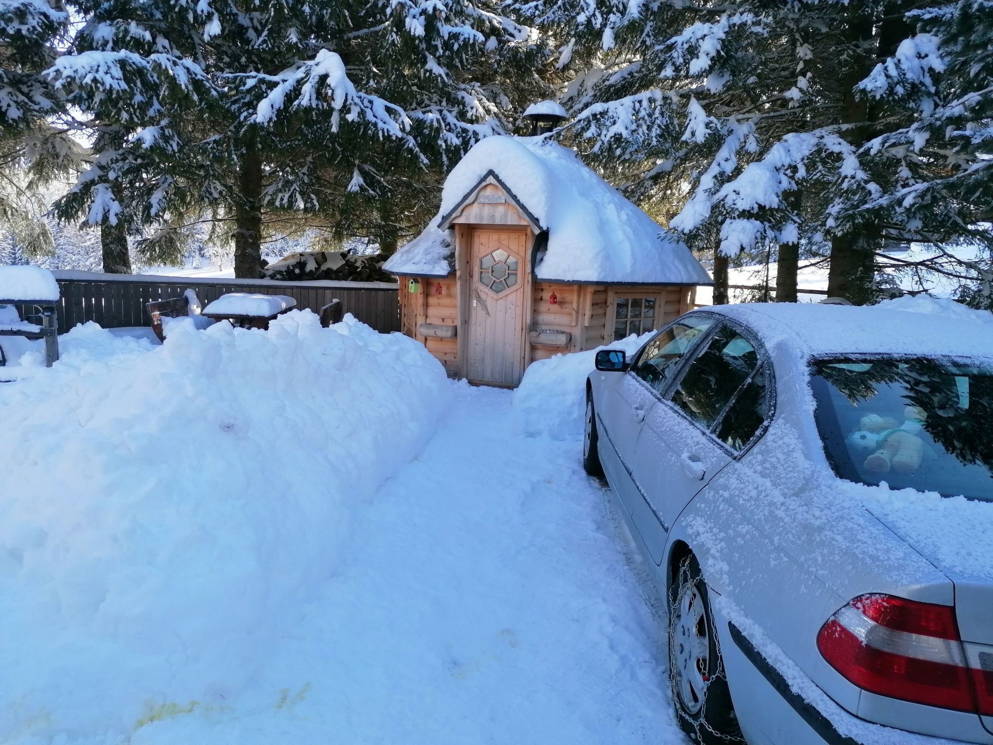 Una cabaña de madera rodeada de árboles cubiertos de nieve.