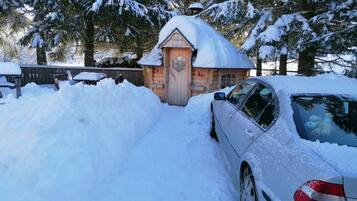 Una cabaña de madera rodeada de árboles cubiertos de nieve.