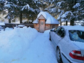 Una cabaña de madera rodeada de árboles cubiertos de nieve.