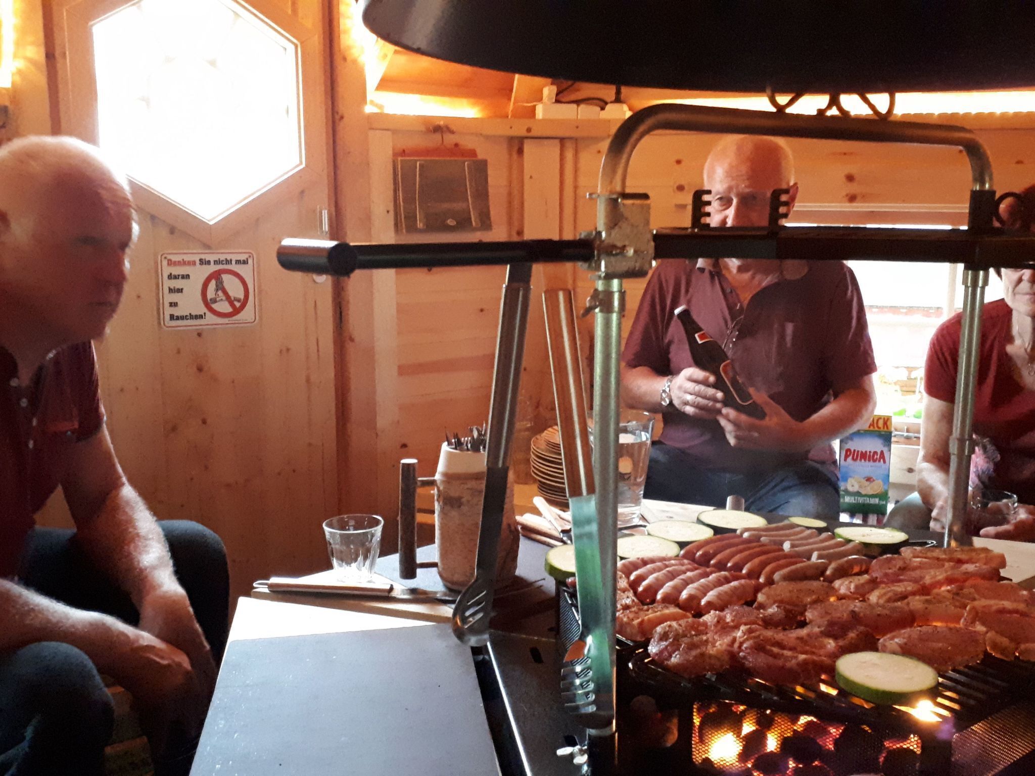 A restaurant with a grill, wooden interior, and a sign prohibiting smoking.
