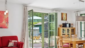 Una sala moderna con un sofá rojo, una mesa de comedor de madera y sillas amarillas.
