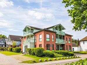A two-story building with a balcony, a brick facade, and a well-maintained garden. - Zeesenhaus 6 by Interhome (Ostseebad Sellin)
