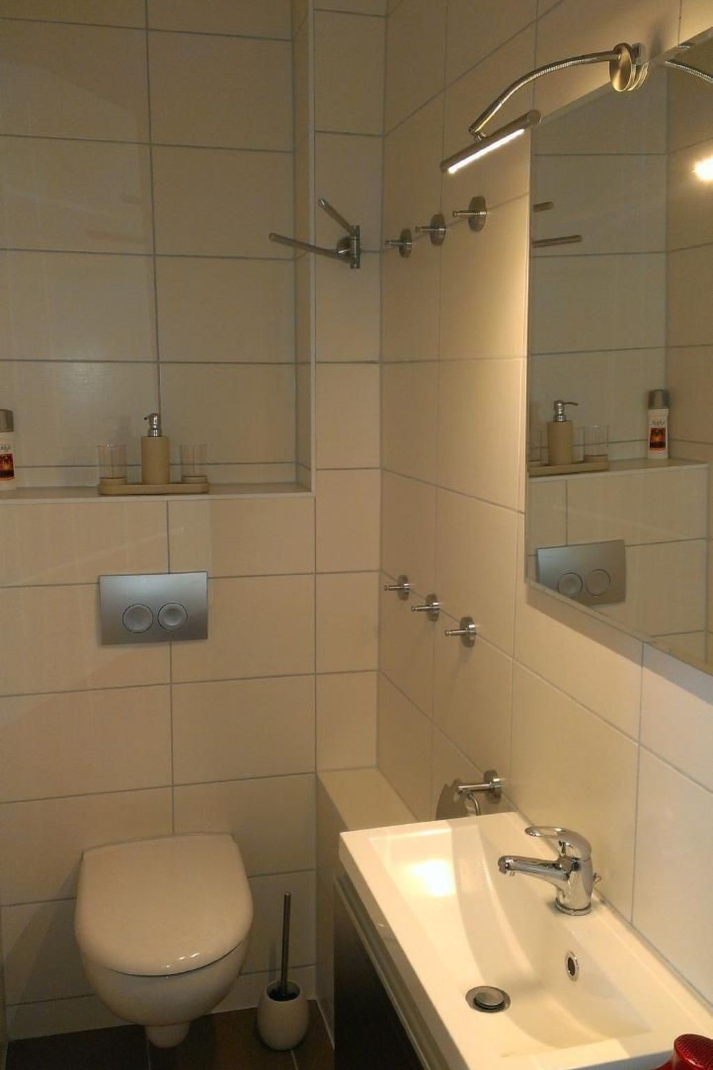 Ein Badezimmer mit Toilette, Waschbecken, Dusche und Spiegel.
