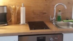 Una cocina equipada con lavavajillas, fregadero y microondas.