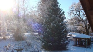 Schneebedeckte Landschaft mit einem Pavillon und einer hohen Nadelbaum.