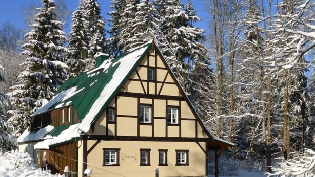 A traditional half-timbered house with a steeply pitched roof, surrounded by snow-covered trees. - Gretelhaus by Interhome (Auerbach)