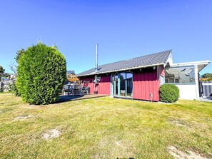 A red building with a chimney, a glass door, and a small tree in the yard. - hygge hus, tolle Ostseelage, freier Blick auf Felder by Interhome (Brodersby)
