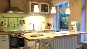 Een keuken met een centraal eiland, een kookplaat en een raam.