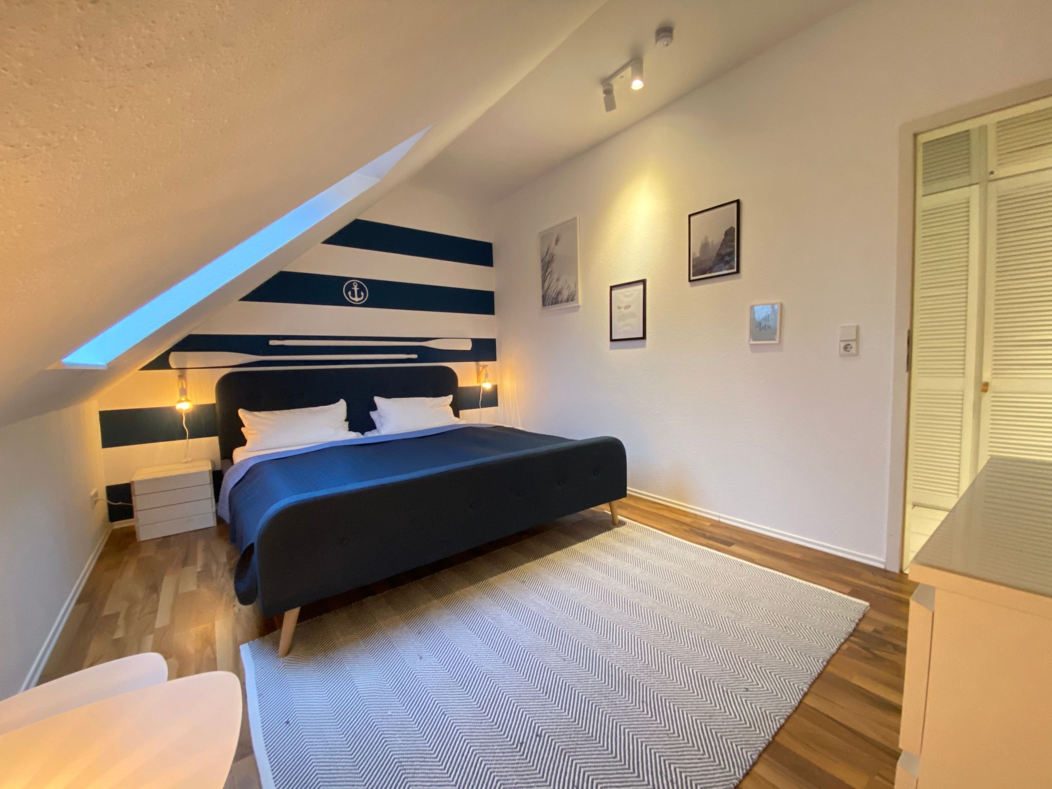 A modern bedroom with a bed, a desk, and a chair.