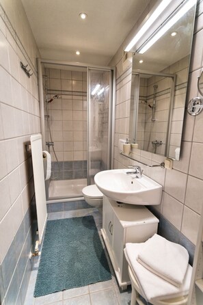 Un baño moderno con ducha, inodoro y lavamanos.