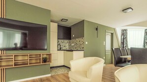 A living room with a flat-screen TV, a sofa, and a dining area with chairs. - Caesar Apartment mit Terrasse, nahe dem Balaton by Interhome (Siofok)