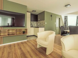 A living room with a flat-screen TV, a sofa, and a dining area with chairs. - Caesar Apartment mit Terrasse, nahe dem Balaton by Interhome (Siofok)